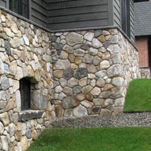 This mountain top retreat has a fieldstone veneer with Caledonia granite coping